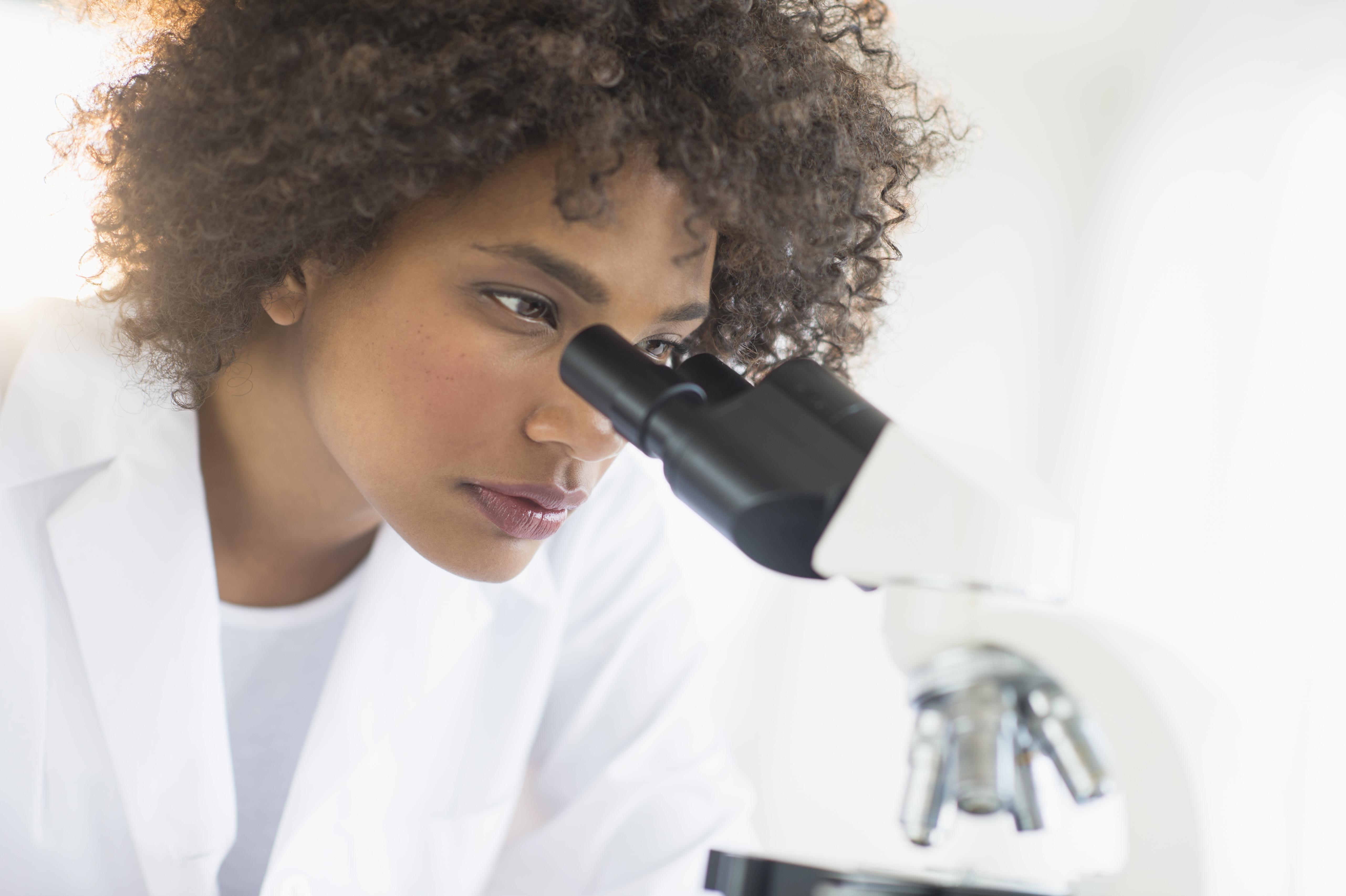 USA, New Jersey, Jersey City, Woman using microscope in laboratory