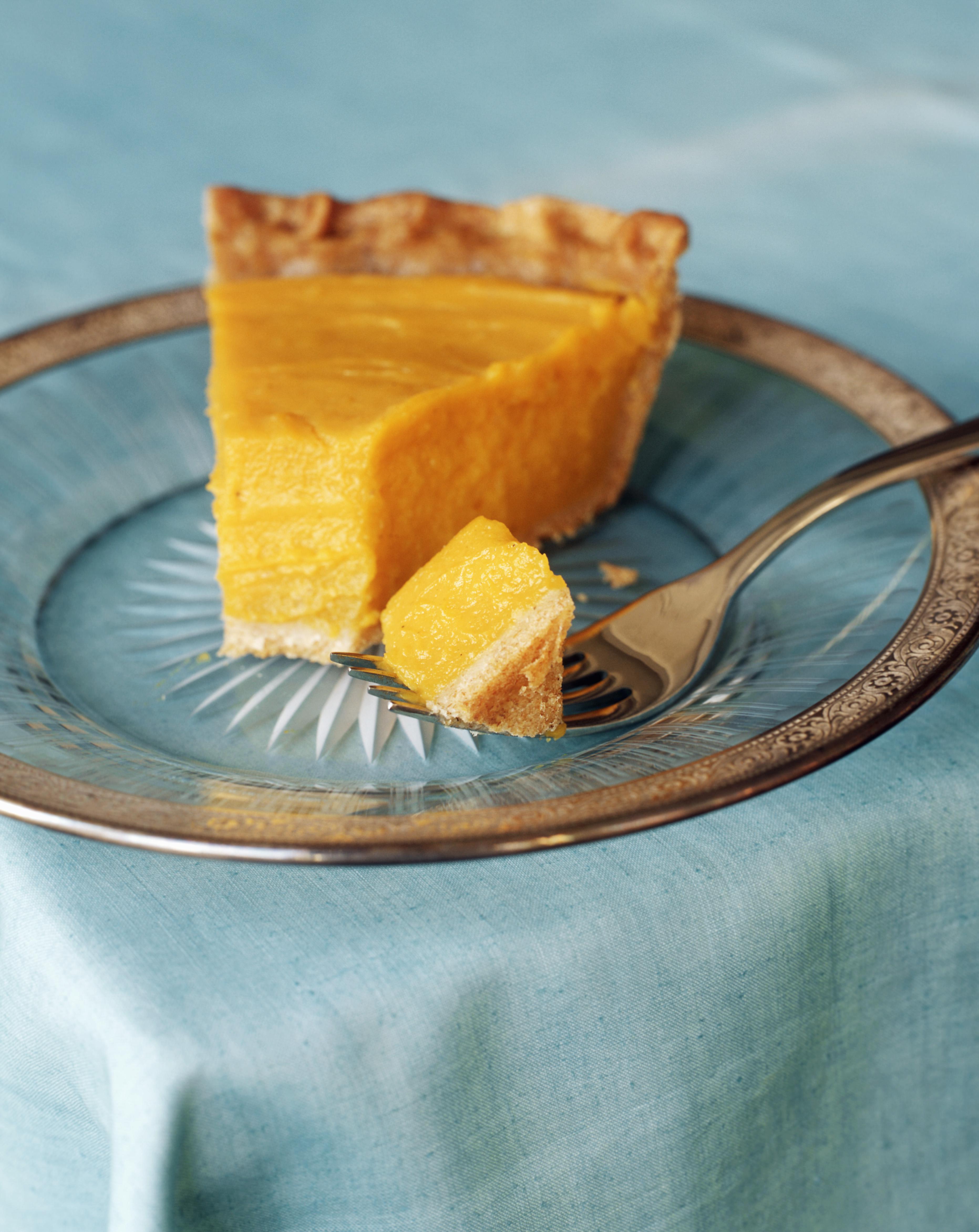 Slice of pumpkin pie with piece on fork, close-up