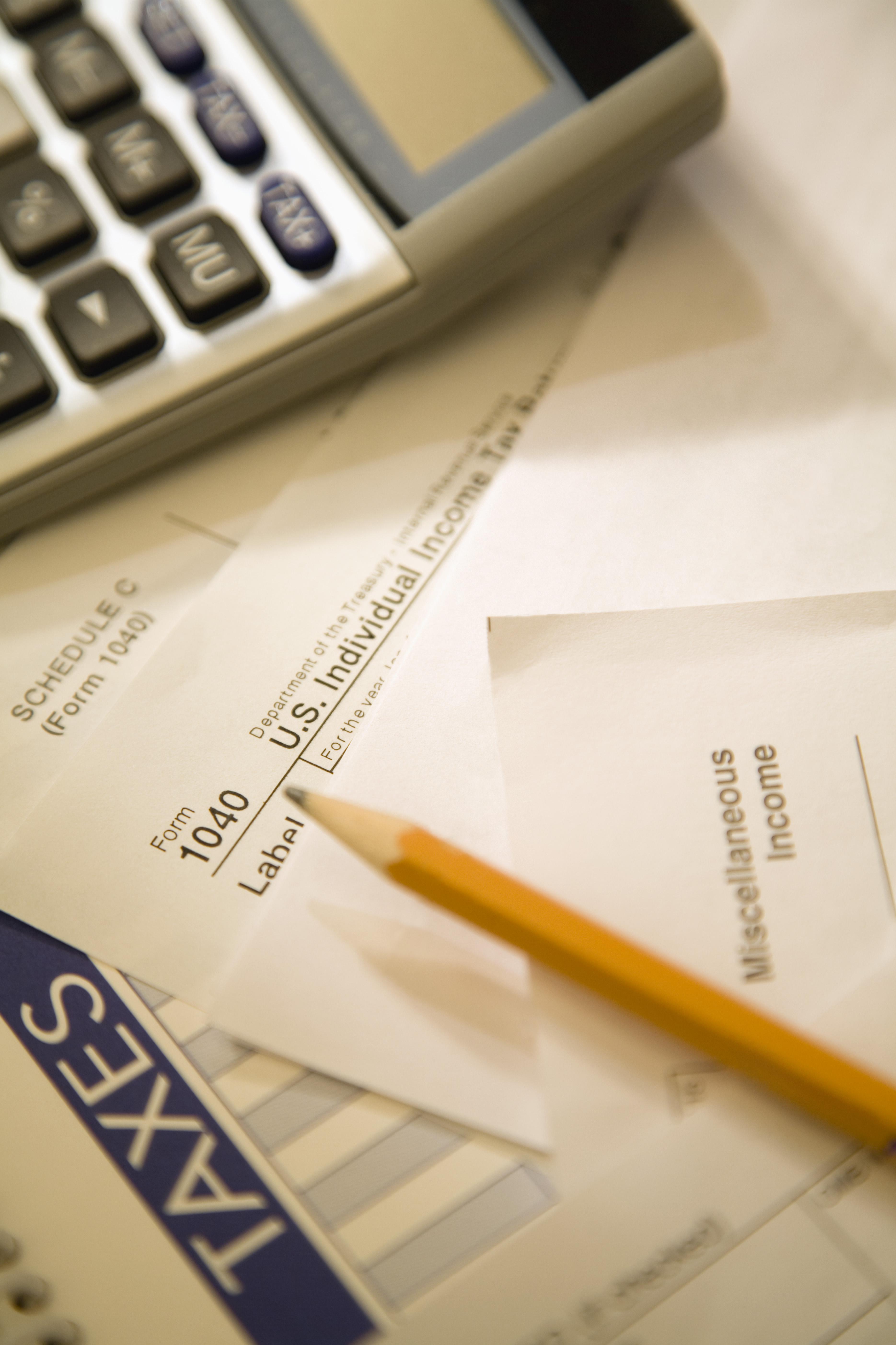 Tax forms with pencil and calculator