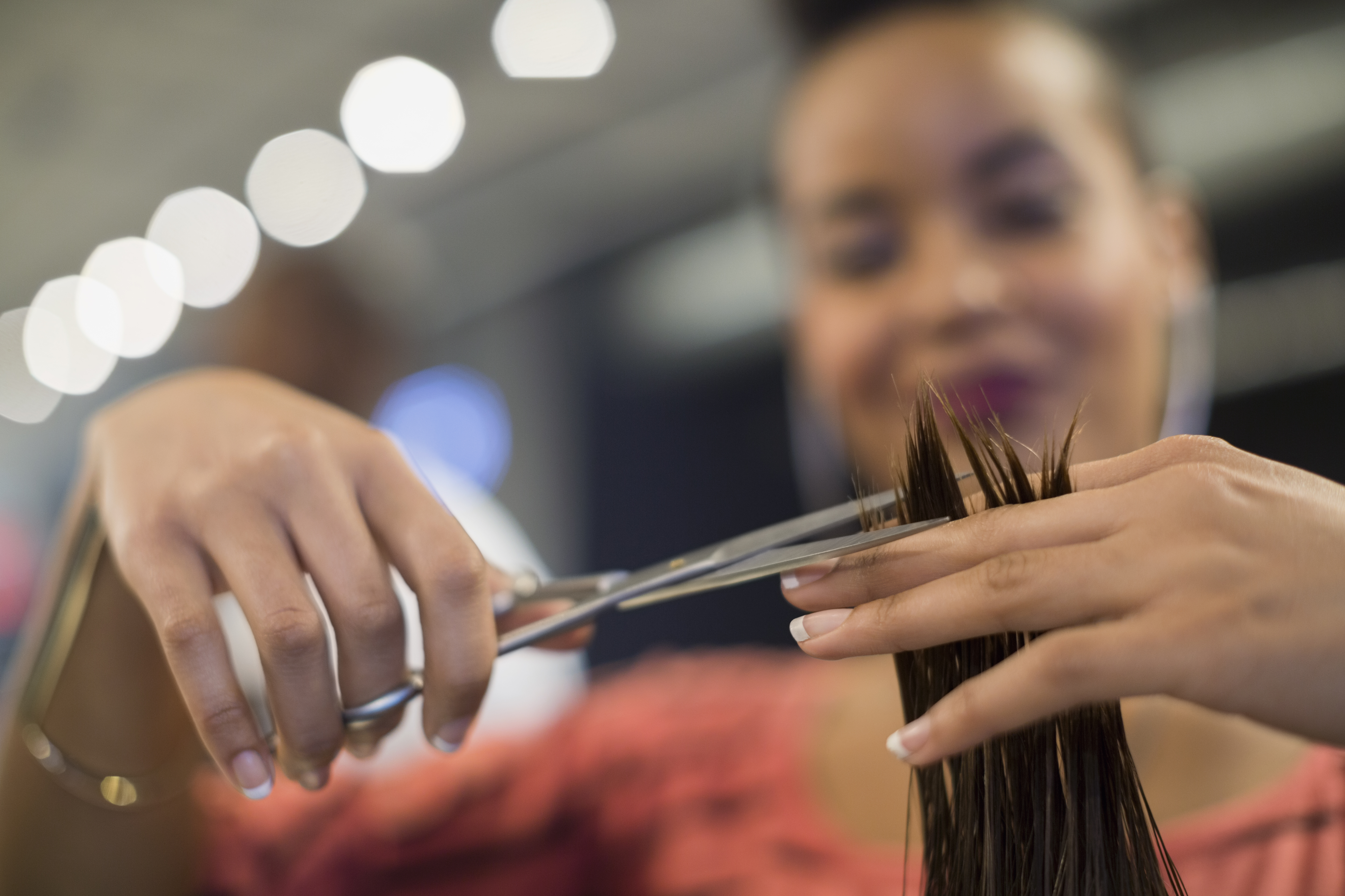 Close up hairstylist cutting hair in hair salon