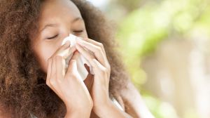 Teenage girl sneezing.