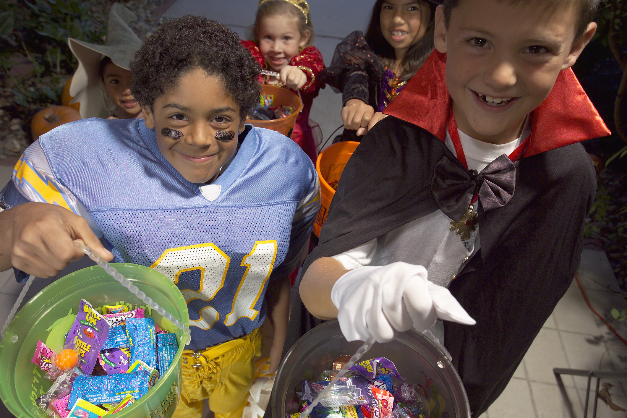 Children (4-8) in Halloween costumes trick-or-treating, elevated view