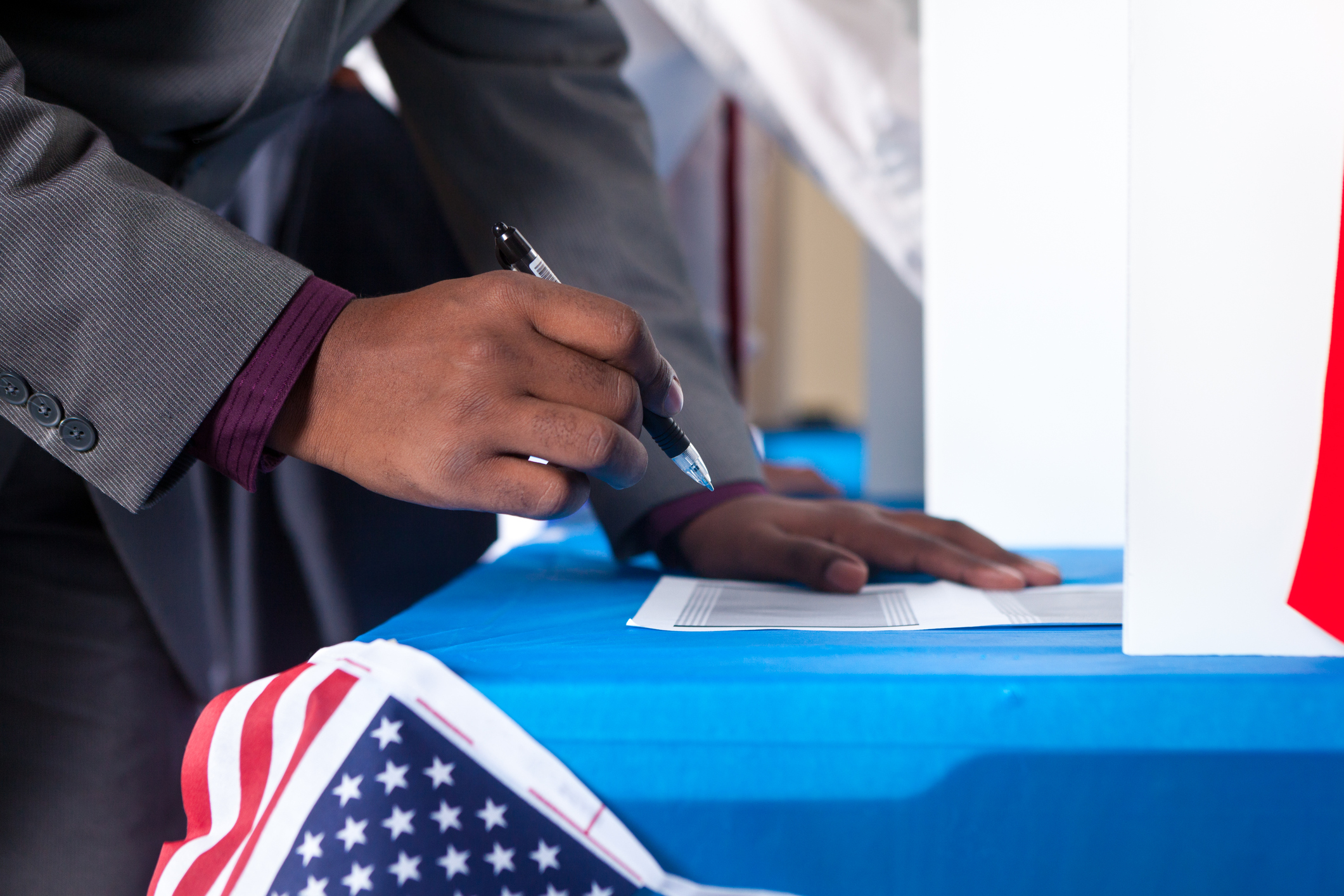 Man's hands while voting in election vote booth