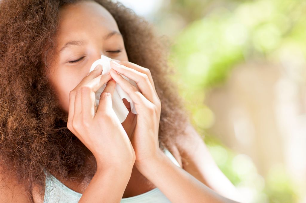 Teenage girl sneezing.