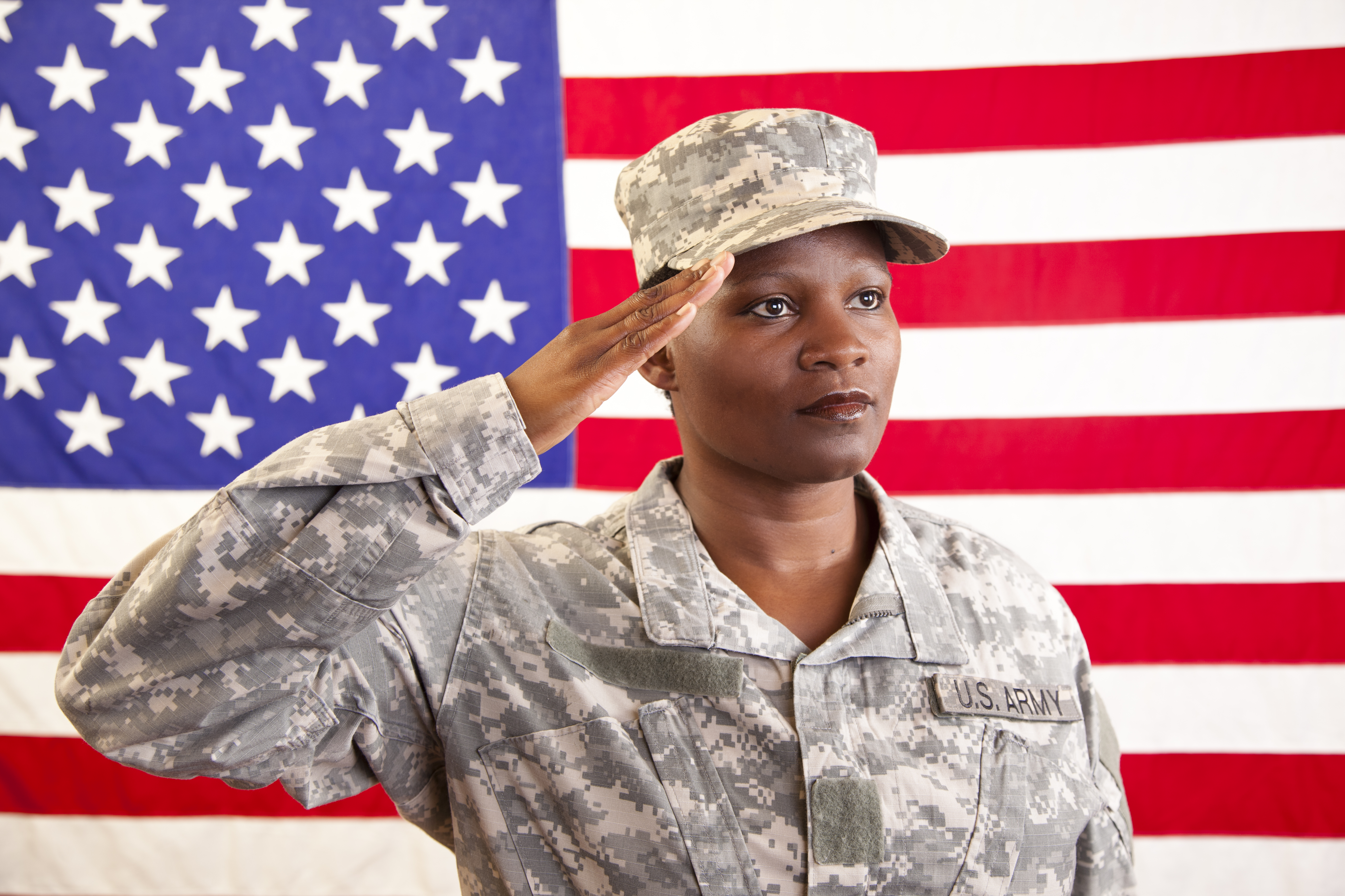 African descent female in military uniform saluting American flag