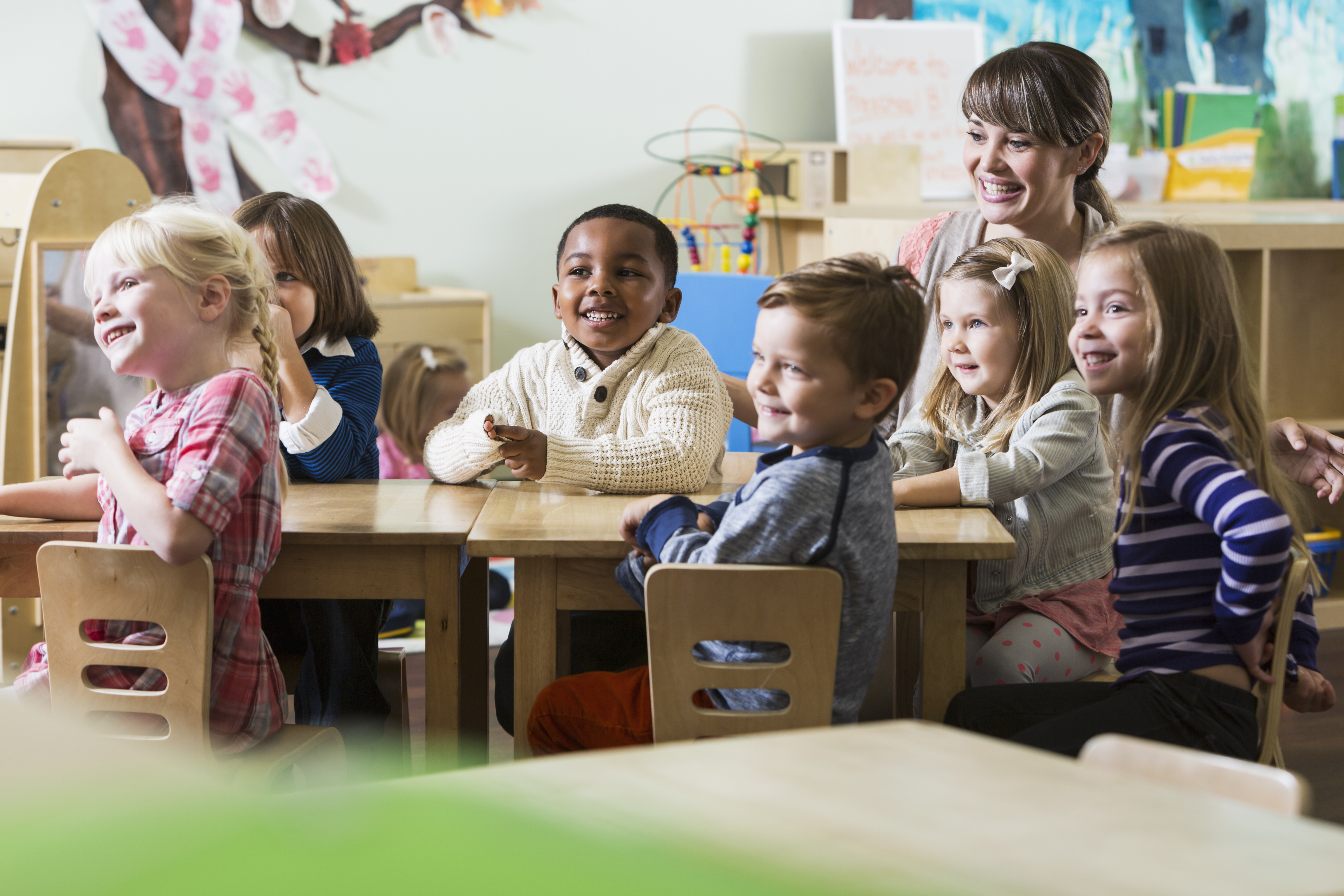 Teacher with group of preschoolers sitting at table