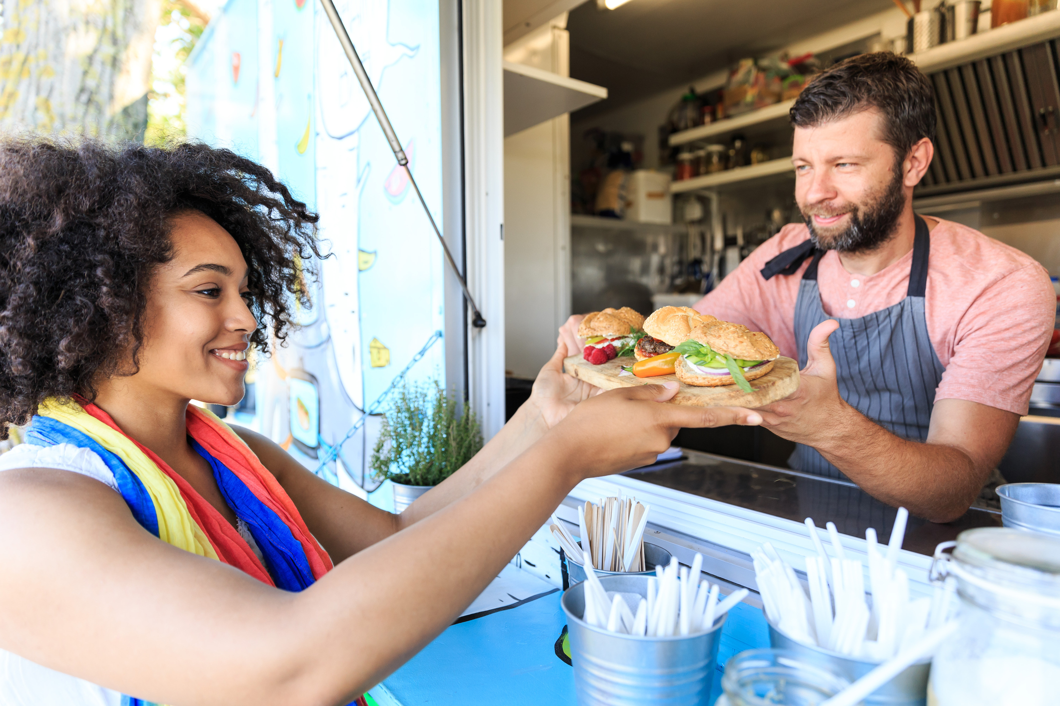 Food truck worker serving sandwiches to customer
