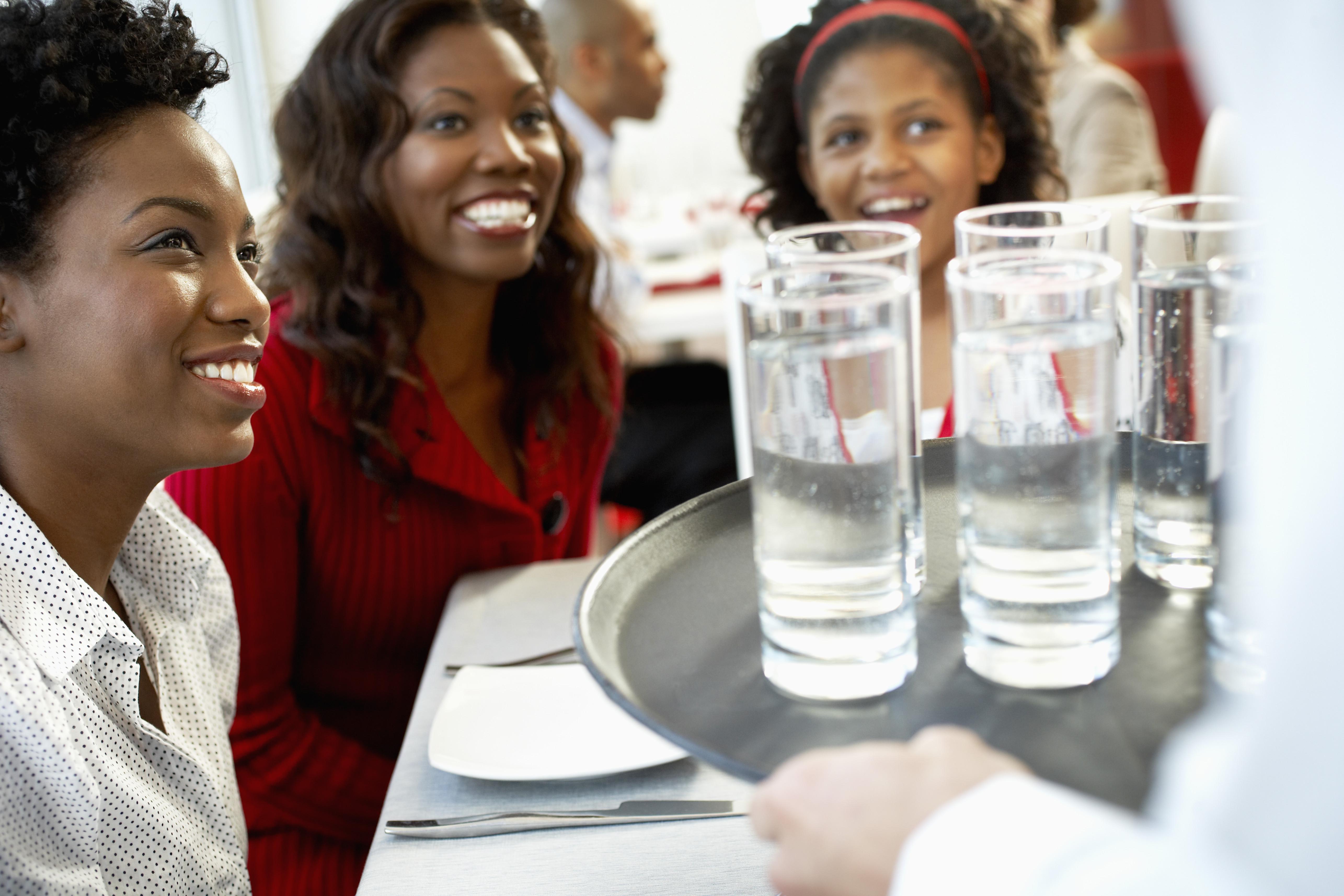Waiter Serving Water to Women