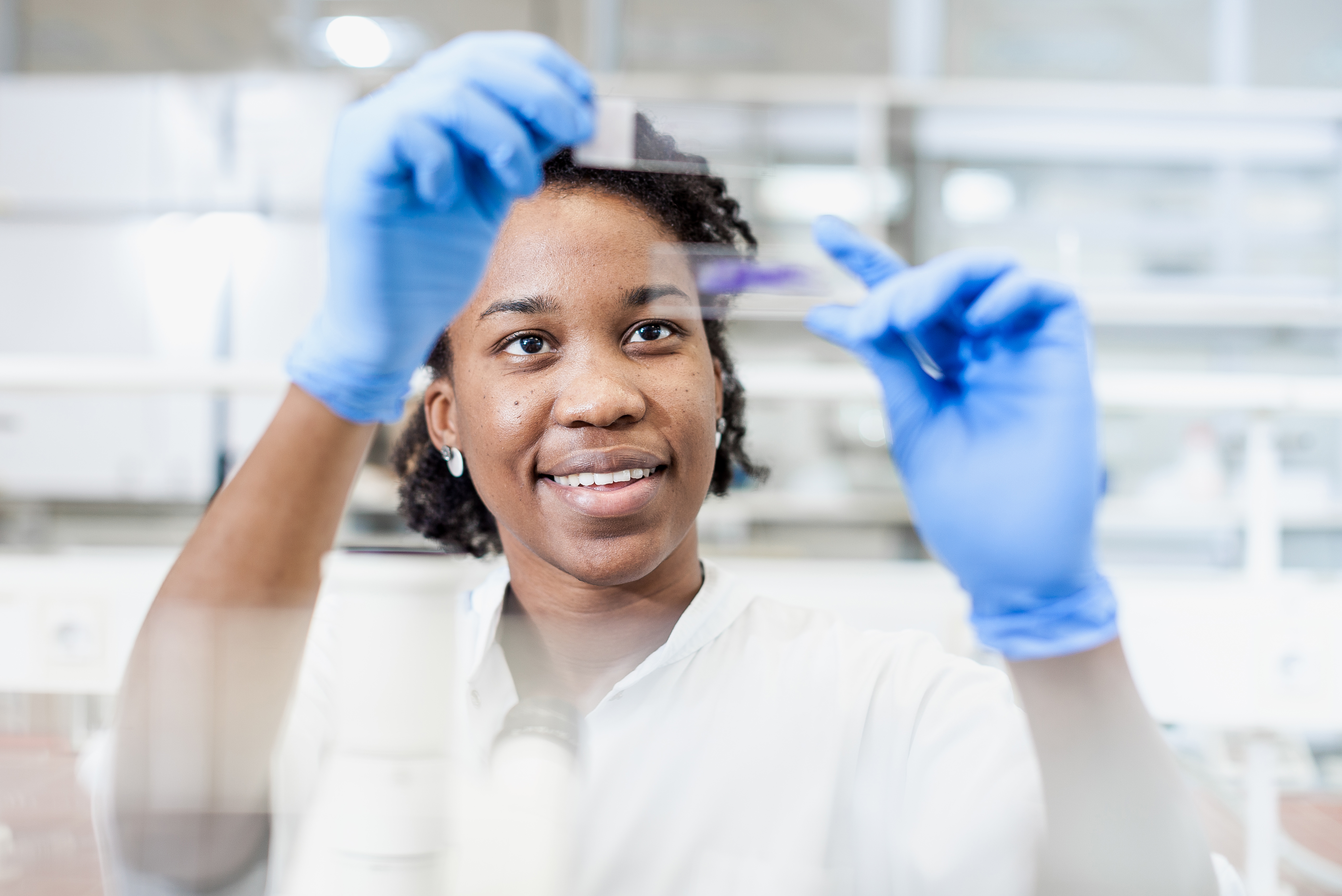 Scientist Looking at a Microscope Slide