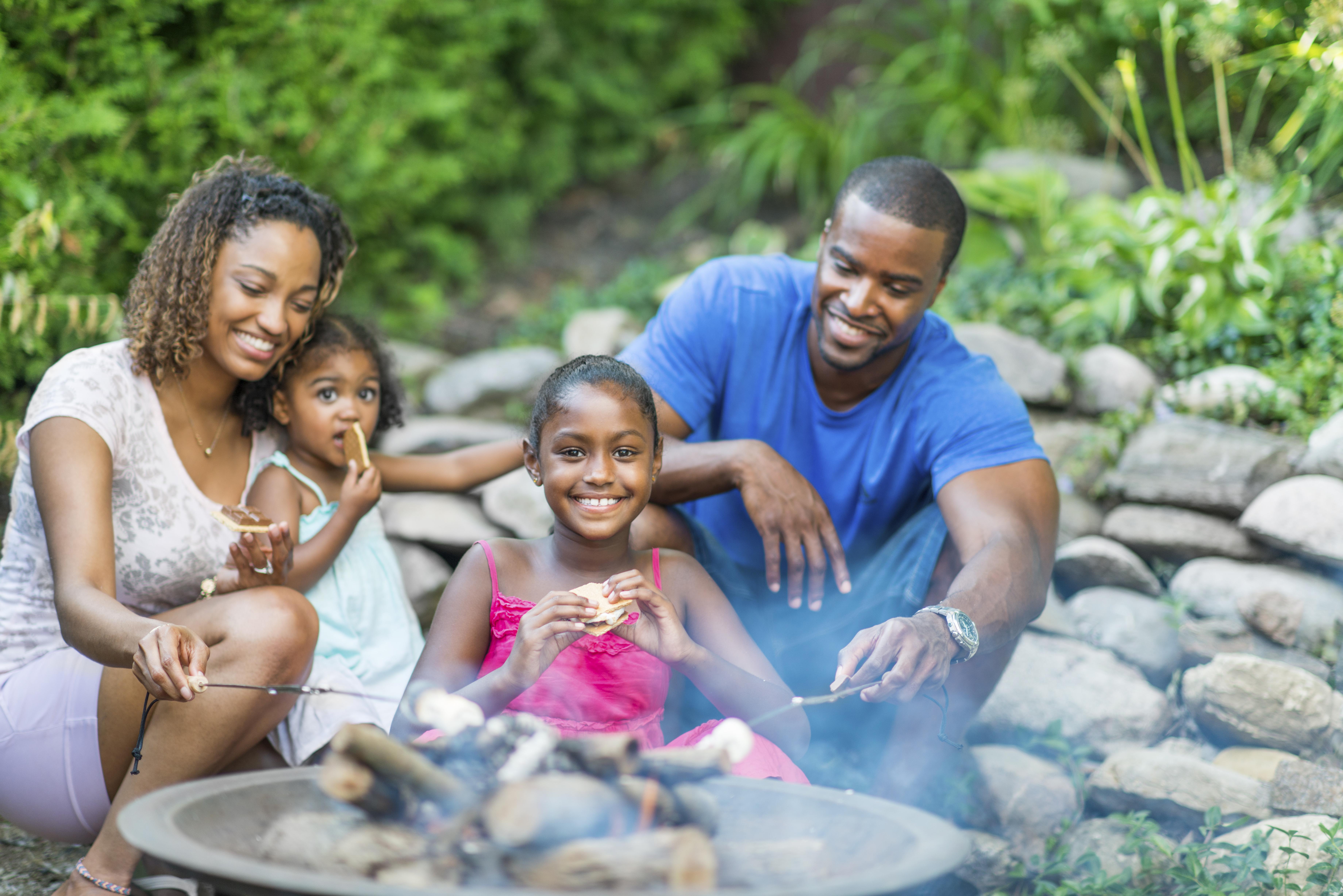 Family roasting marshmallows over the fire