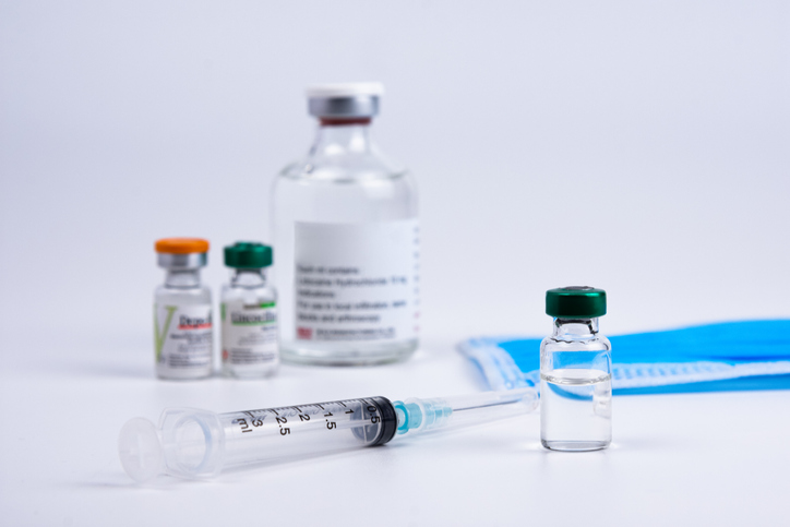 Bottle with vaccine against covid-19 and syringe on white background for background usage Vial with,Oradea,Romania