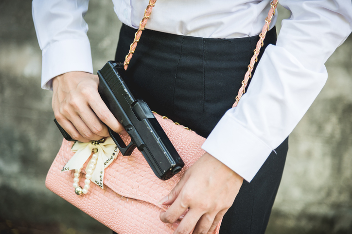 Young woman self defence putting gun