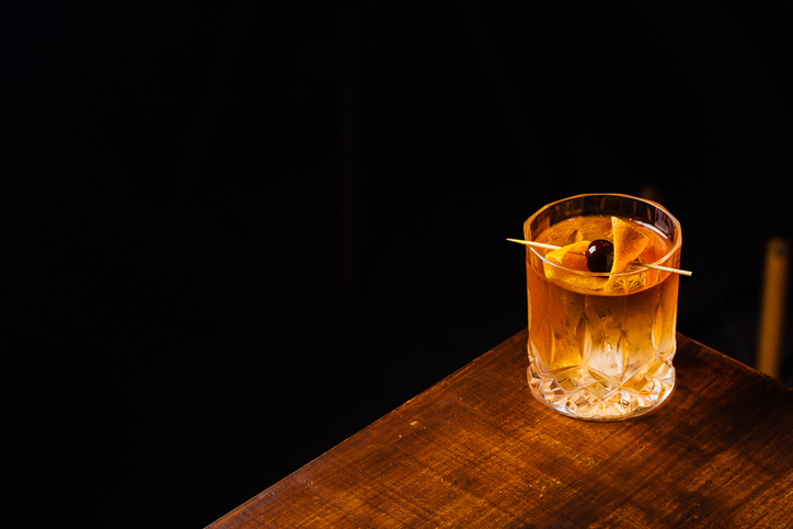 Alcoholic Old Fashioned Cocktail classic Bourbon Whiskey, sugar cube and aromatic bitters garnish with orange peel and a cherry