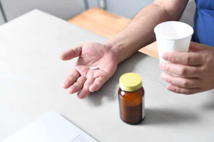 Hand of an Asian senior man taking medicine
