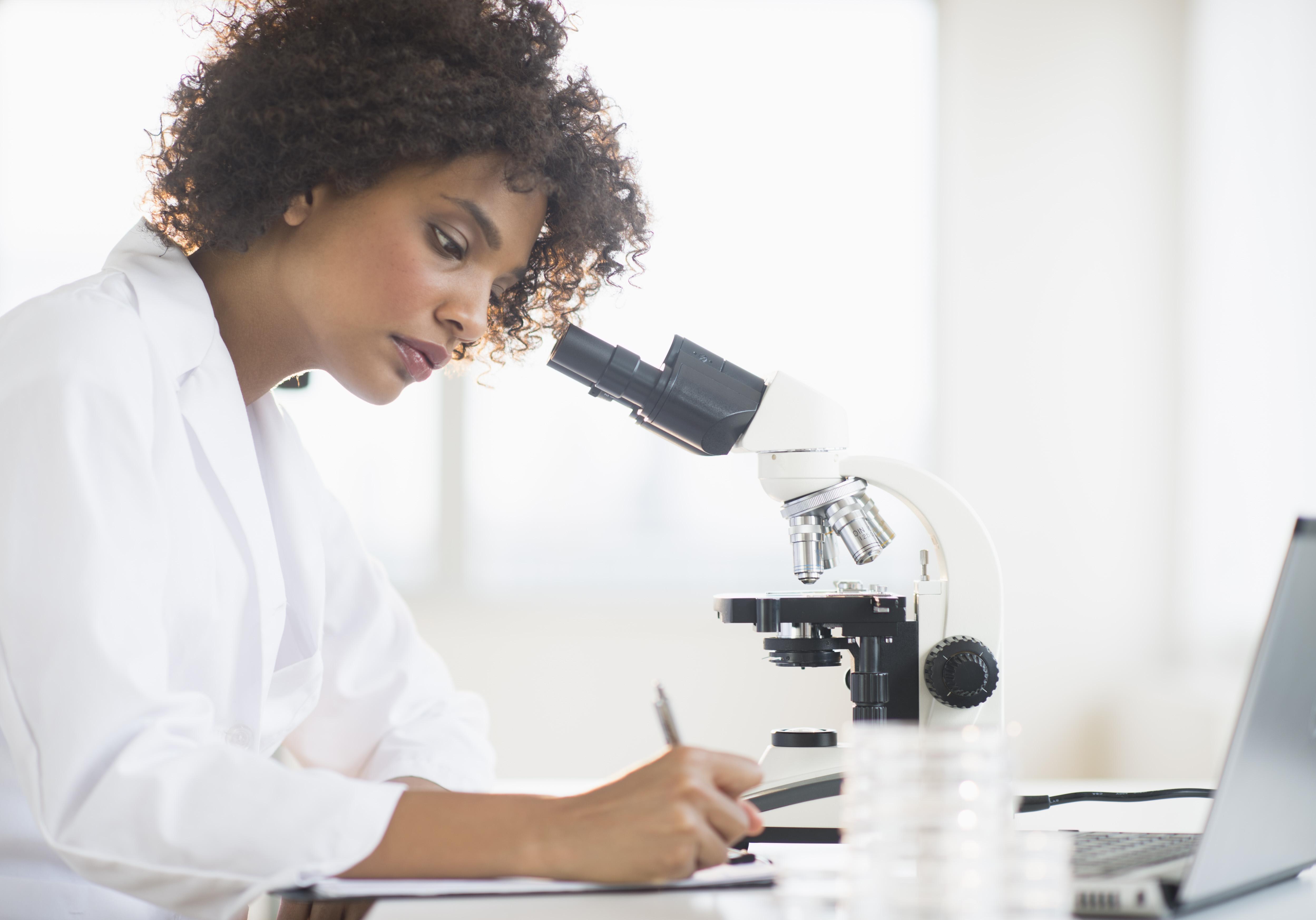 USA, New Jersey, Jersey City, Woman using microscope in laboratory