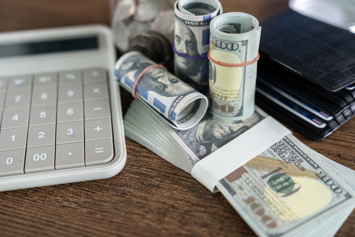 A Calculator and dollar bills on a table. The concept of financial accounting of business entities, expenses and income
