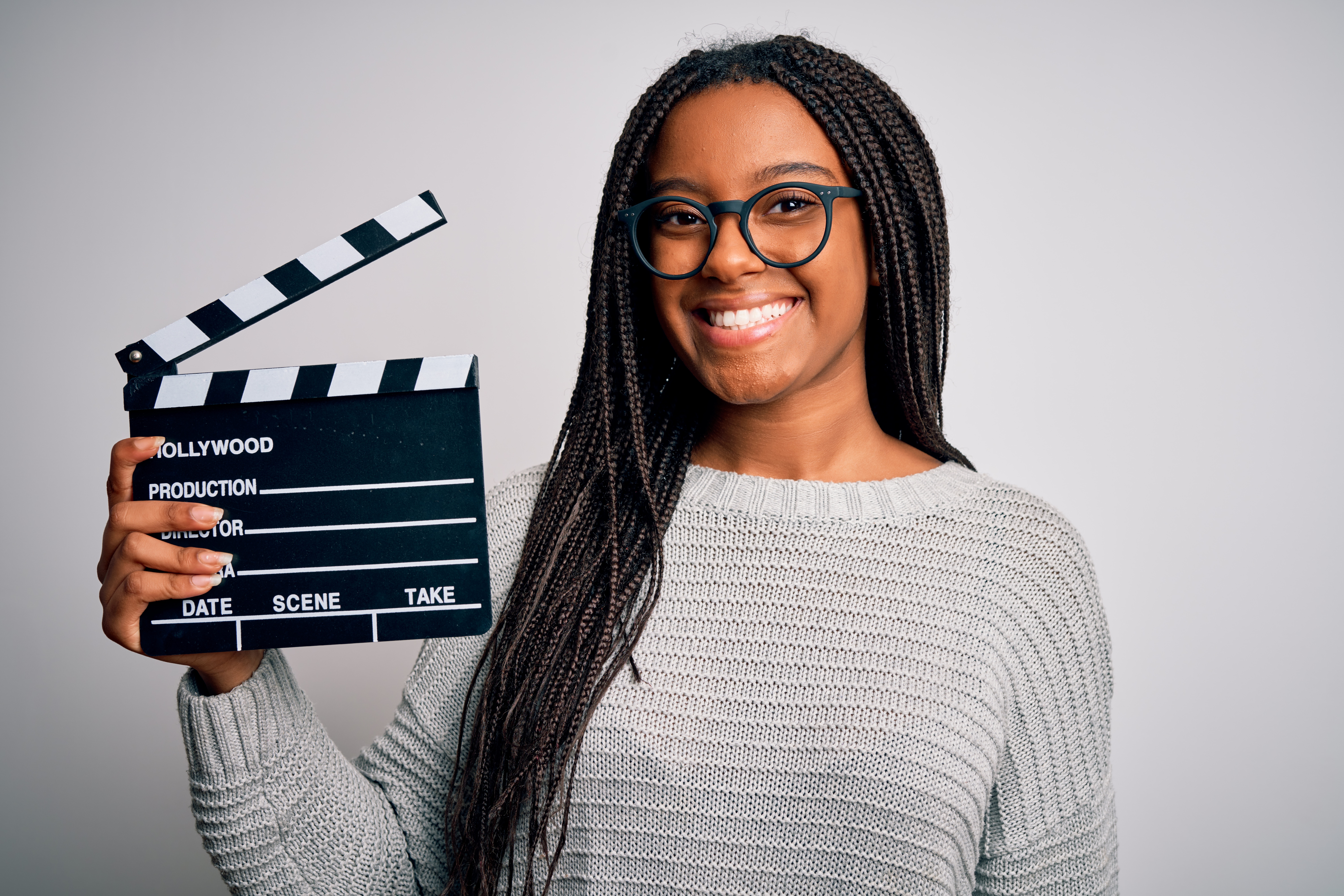Young african american director girl filming a movie using clapboard