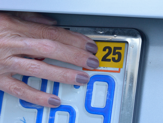 Annual registration sticker being applied to license plate