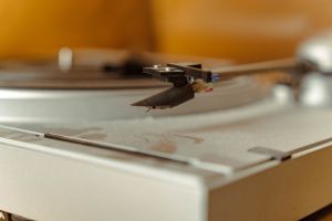 Close-up of a turntable needle cartridge playing a vinyl record, evoking nostalgia and the warm sound of analog music