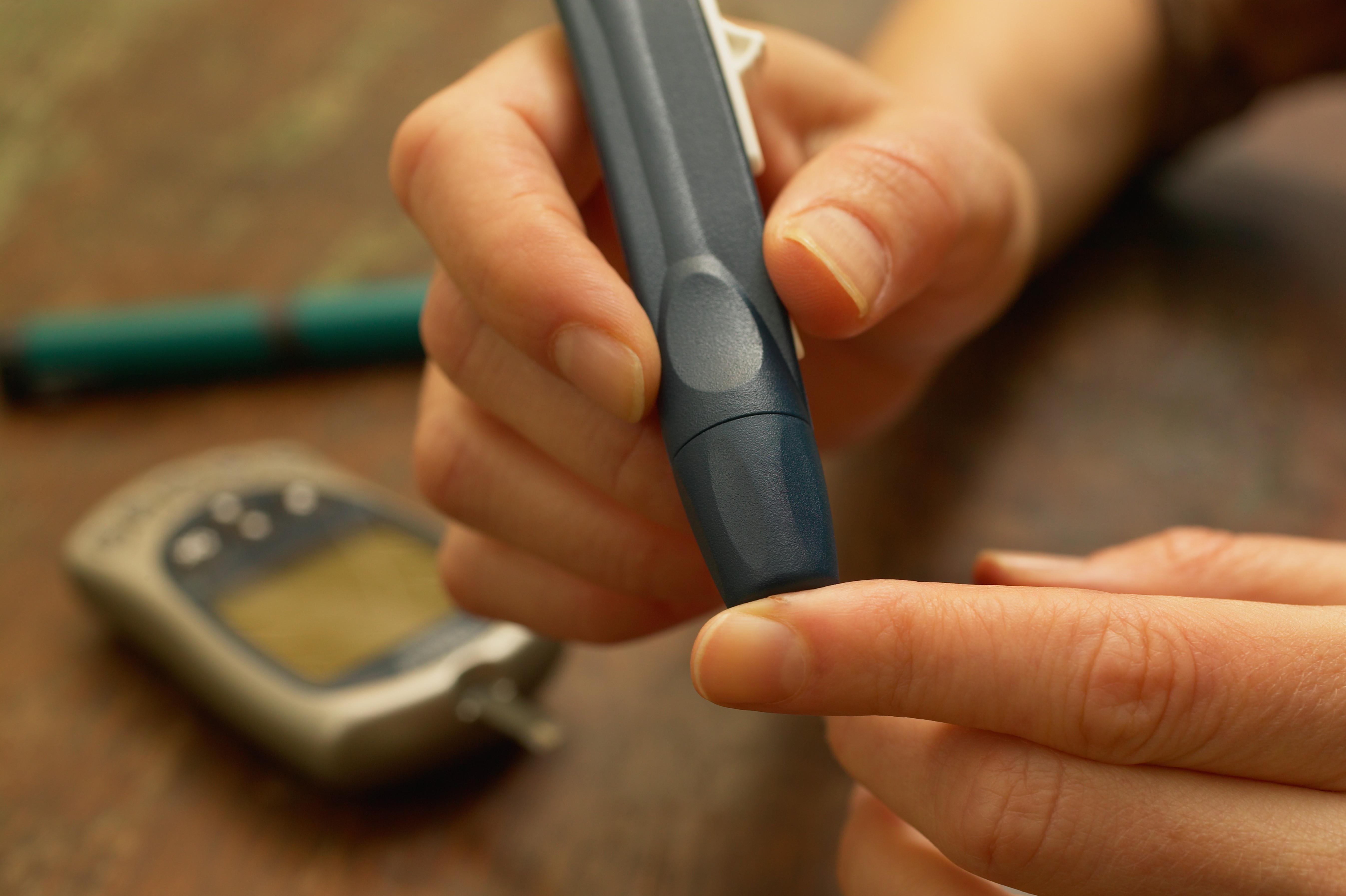 Diabetic female patient checking blood sugar, close-up
